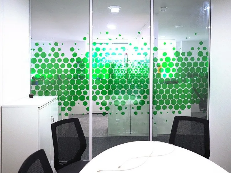 Salle de réunion vitrée habillée d'un dégradé de bulles vertes translucides