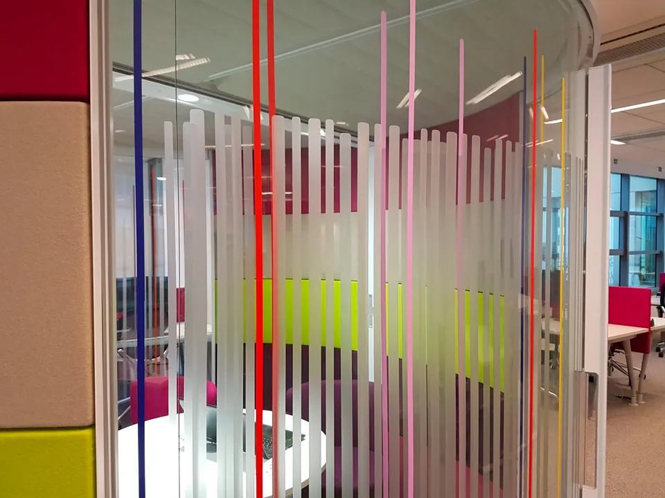 Salle de réunion vitrée habillée de lignes verticales colorées et dépolies