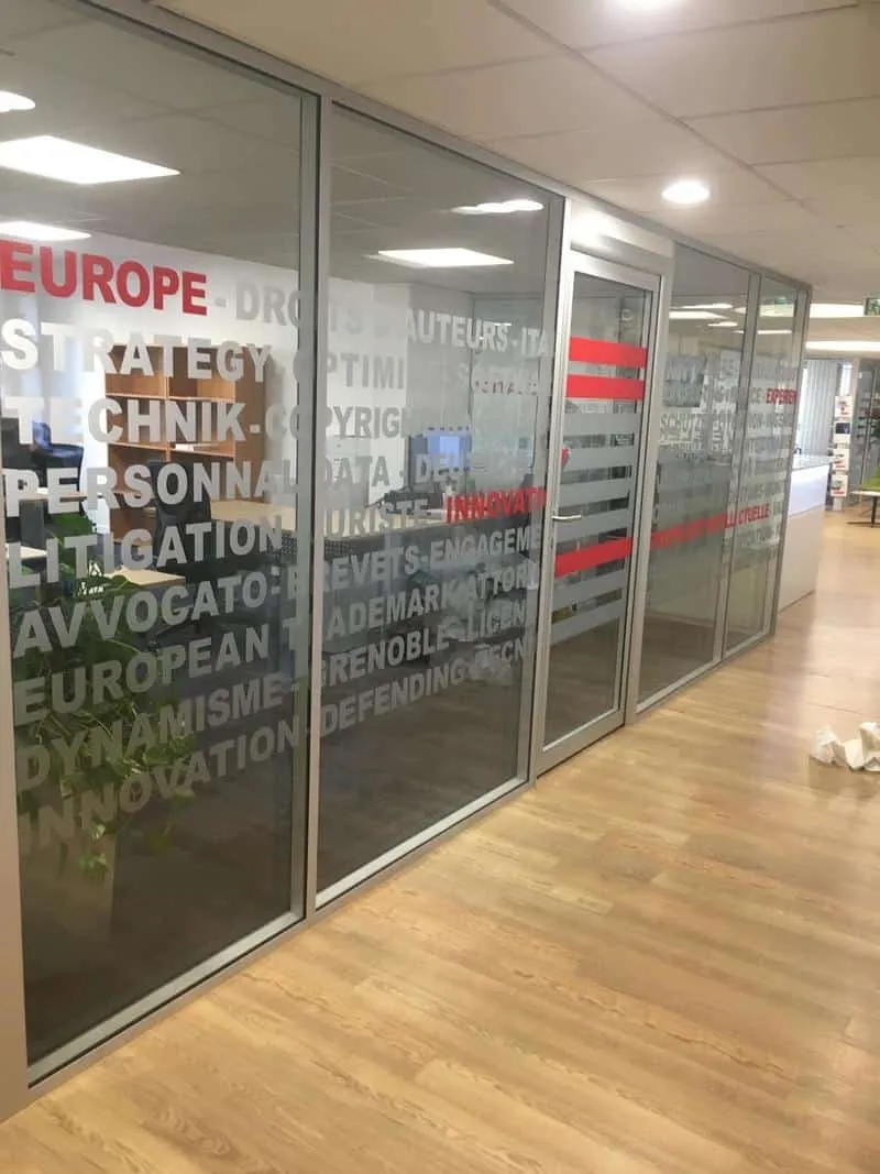 Cloison vitrée de bureau avec des mots adhésifs en bandes horizontales